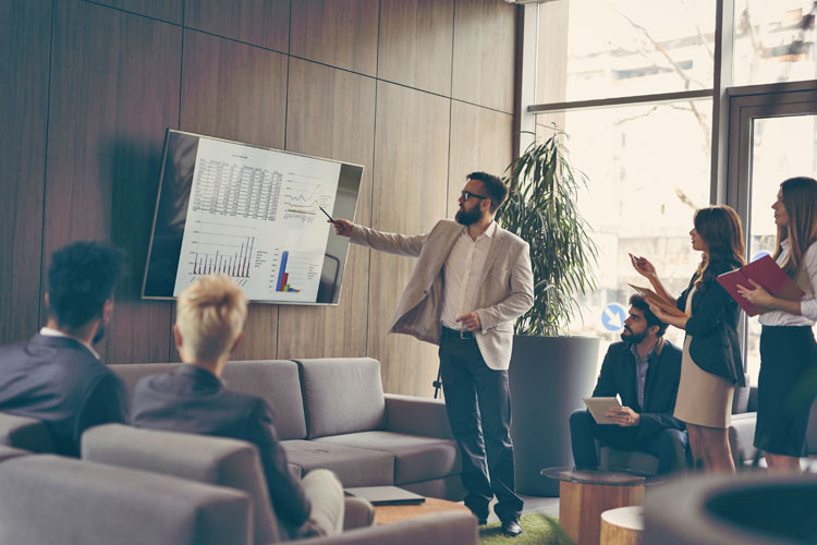 Man sitting at desk holding month planner.